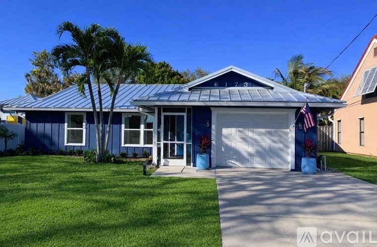 A blue house with a garage door and a flag on the front.