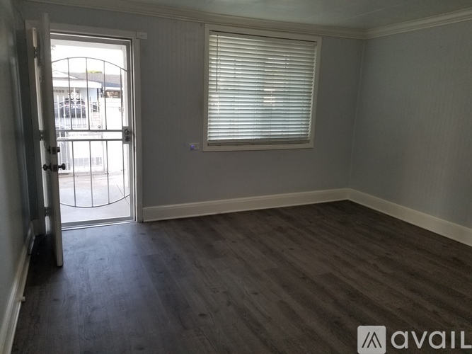 A room with a door and a window with blinds.
