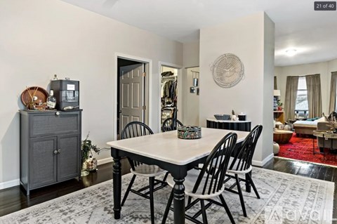A dining room with a white table and black chairs.