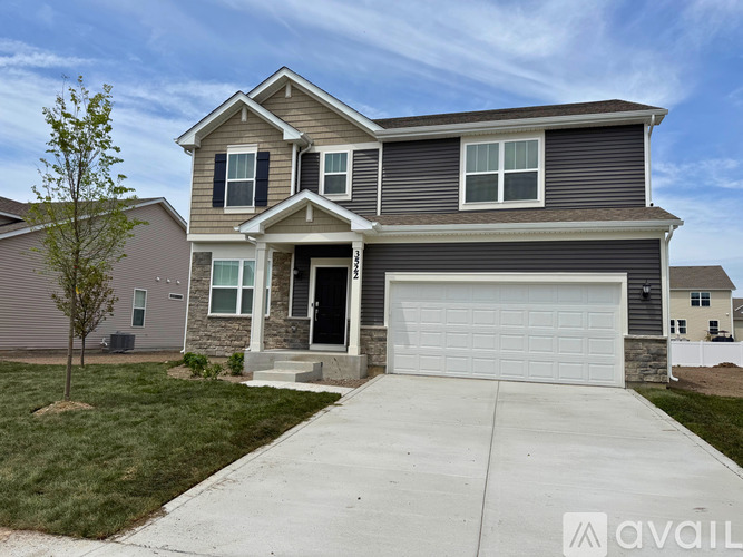 A two-story house with a garage is available for sale.
