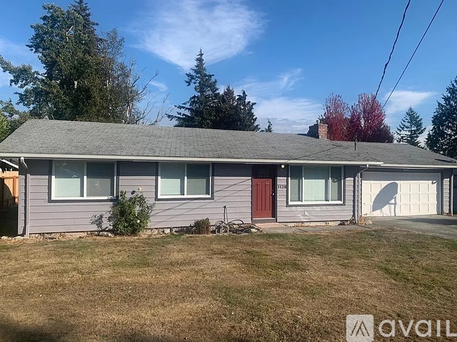 A house with a grey roof and a red door is for sale.