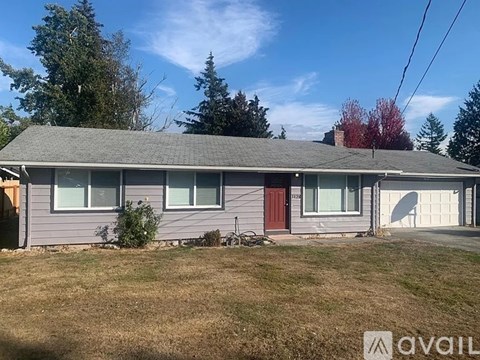 A house with a grey roof and a red door is for sale.