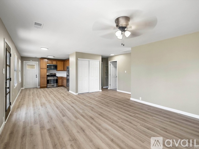 A spacious room with a ceiling fan and lighting fixture.