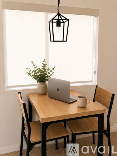 A table with a laptop and a plant on it.