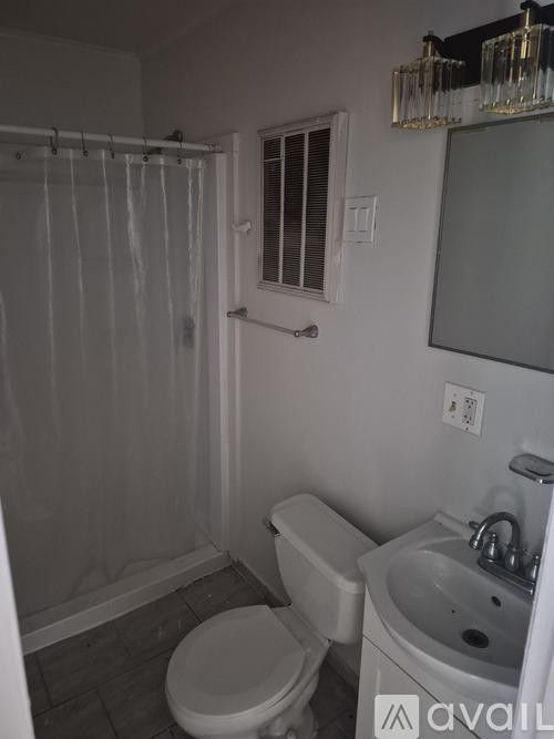 A bathroom with a toilet, sink, and shower.