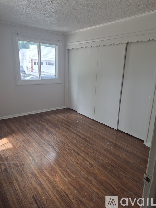 A room with wooden flooring and a window.