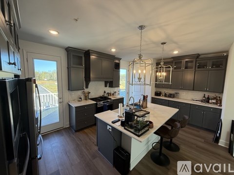 A modern kitchen with a large island and a refrigerator.