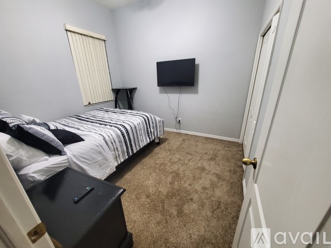 A bedroom with a bed, a TV, and a nightstand.