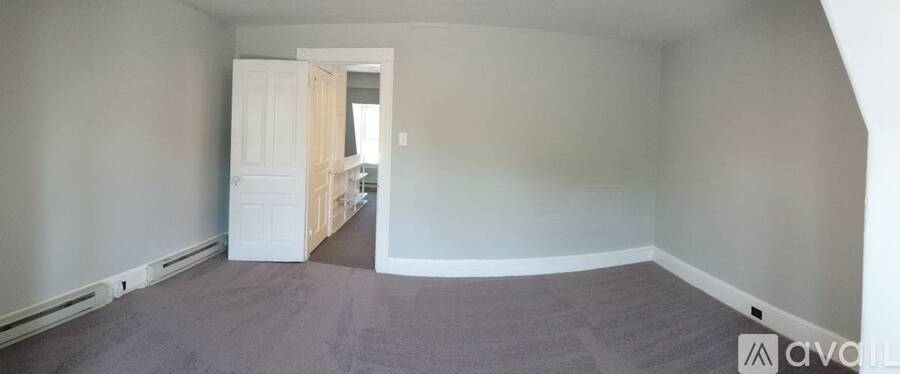 A room with a carpeted floor and a doorway leading to another room.