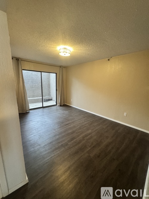 A room with wooden flooring and a sliding glass door.
