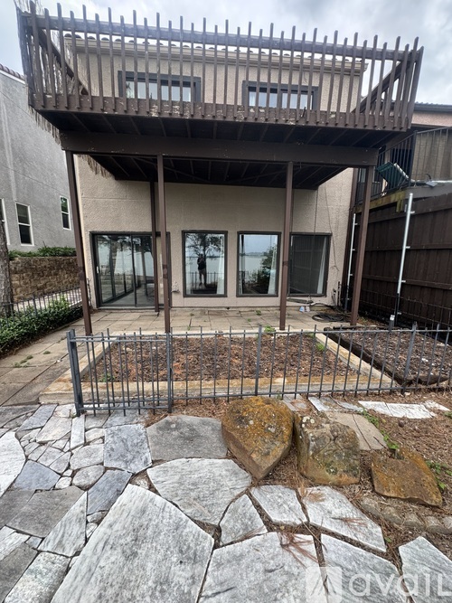A patio area with a stone walkway and a wooden pergola.