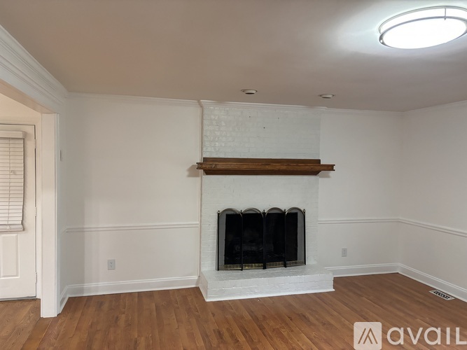 A living room with a fireplace and wood flooring.