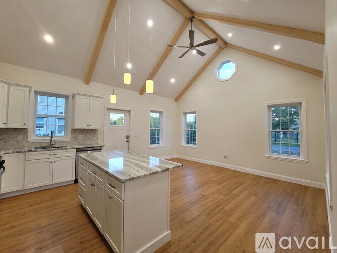 A spacious kitchen with wooden floors and a central island.