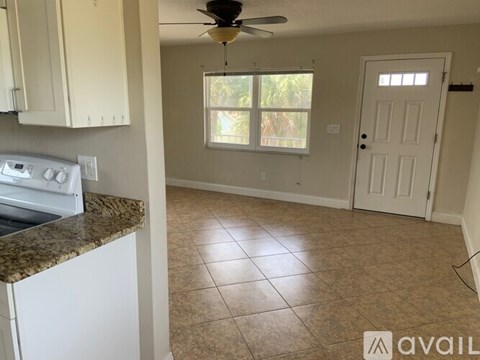 A kitchen with white cabinets and a marble countertop.