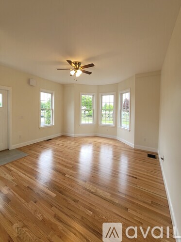 A room with wooden flooring and a ceiling fan.