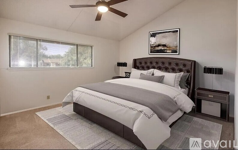 A bedroom with a large bed and a ceiling fan.