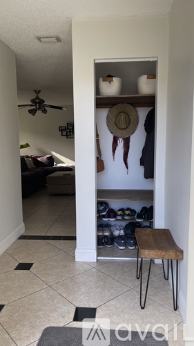 A room with a bench and a shoe rack.