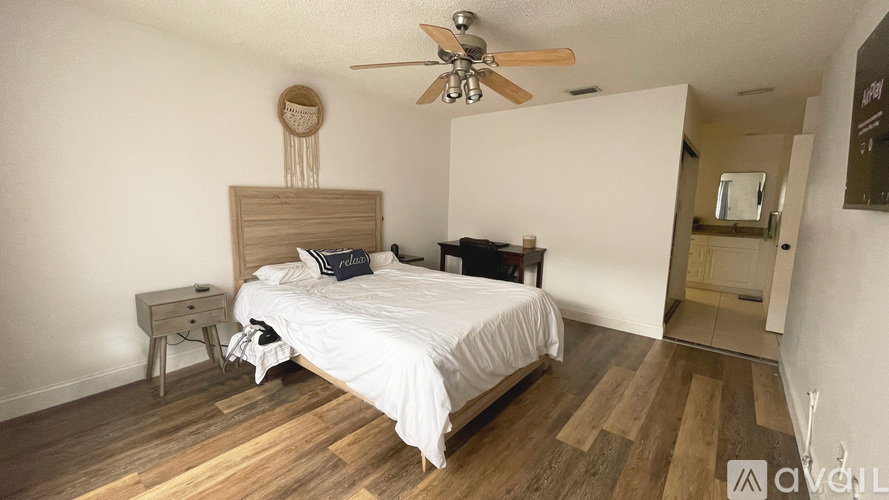 A bedroom with a bed, nightstand, and a ceiling fan.