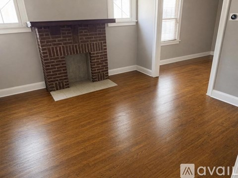 A room with a fireplace and wooden flooring.