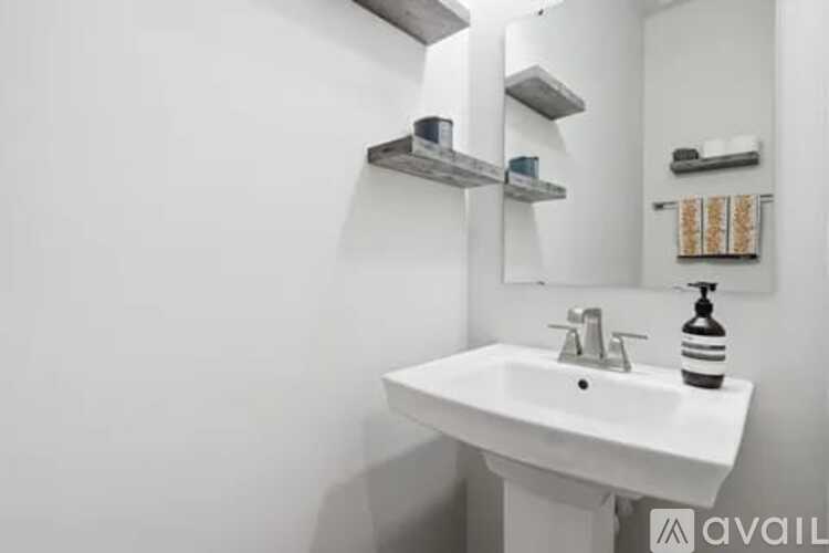 A white sink with a silver faucet and a soap dispenser on a counter.