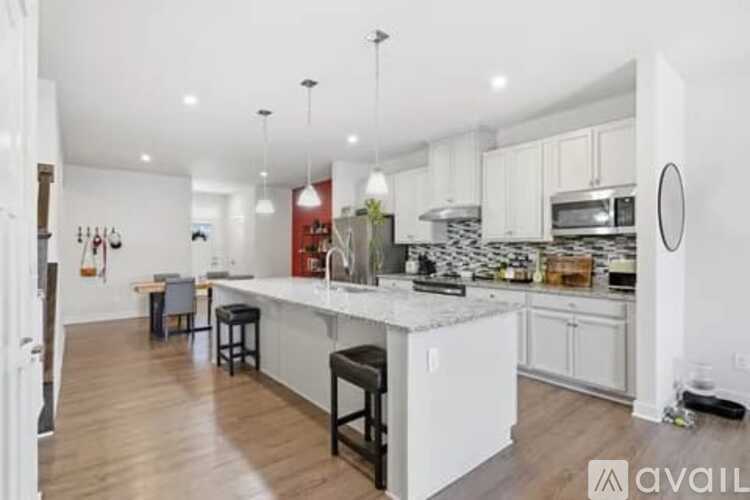 A kitchen with white cabinets and a wooden floor.