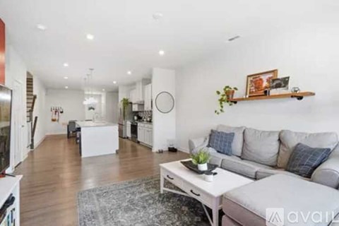 A living room with a grey couch and a white coffee table.