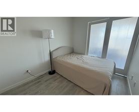 A bedroom with a bed, lamp, and sliding glass doors.