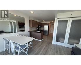 A white table and chairs are in a modern kitchen with a refrigerator and cabinets.