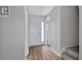 A hallway with a white door and a wooden floor.