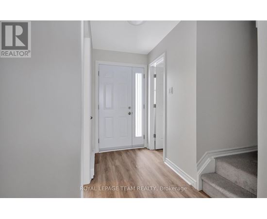 A hallway with a white door and a wooden floor.