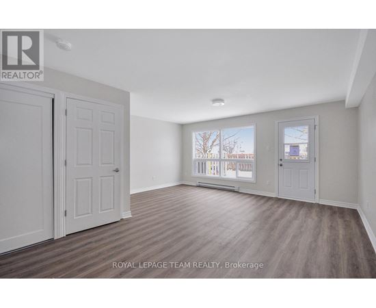A room with a white door and a window with a view of a building outside.