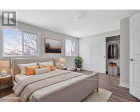 A bedroom with a large bed and a painting on the wall.