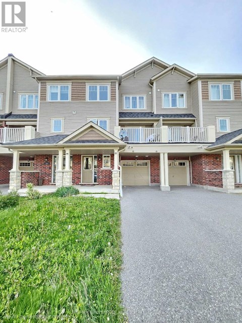 A large, multi-story residential building with a balcony and multiple garage doors.