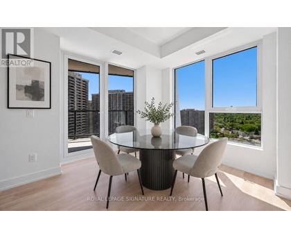 A dining room with a glass table and chairs with a view of the city.