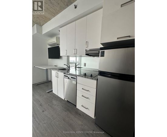 A modern kitchen with white cabinets and stainless steel appliances.