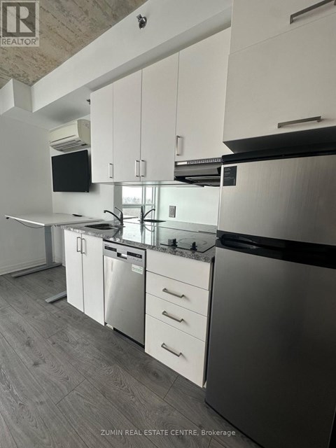 A modern kitchen with white cabinets and stainless steel appliances.