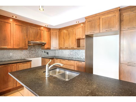 A kitchen with wooden cabinets and a granite countertop.