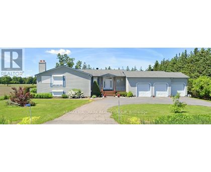 A house with a grey roof and a white garage door is for sale.