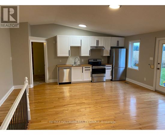 A kitchen with white cabinets and a wooden floor.