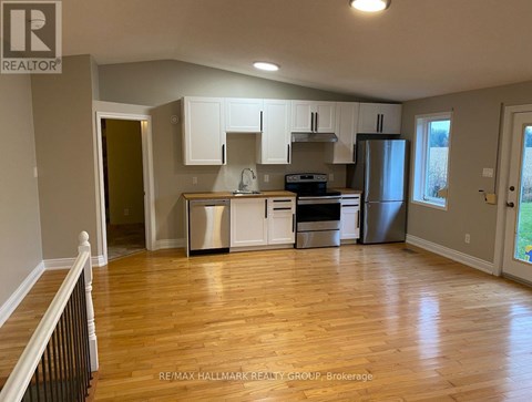 A kitchen with white cabinets and a wooden floor.