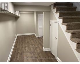 A hallway with a staircase and a white door.