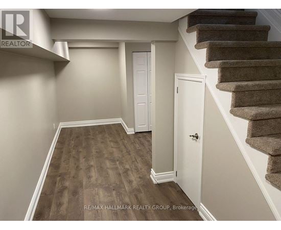 A hallway with a staircase and a white door.