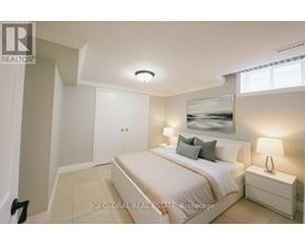 A bedroom with a bed, nightstand, and lamp.