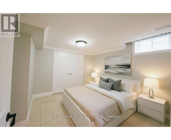 A bedroom with a bed, nightstand, and lamp.
