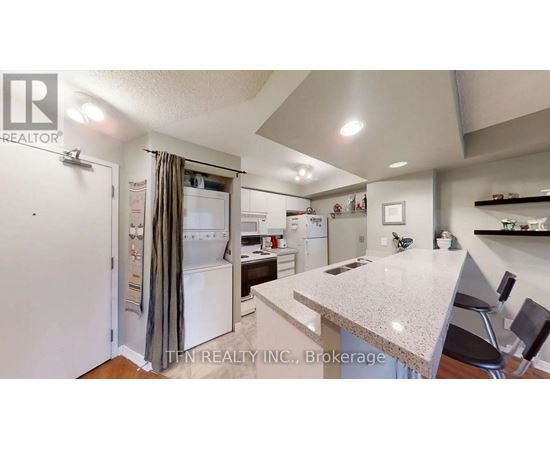 A kitchen with a white refrigerator and a counter top.