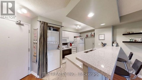 A kitchen with a white refrigerator and a counter top.