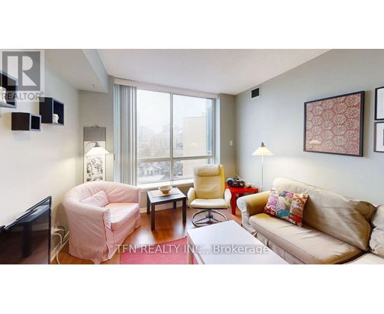 A living room with a couch, chair, and television.
