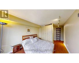 A bedroom with a bed, nightstand, and lamp.