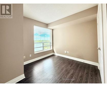 A room with a window and wooden flooring.
