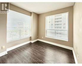 A room with a large window and a view of a building across the street.